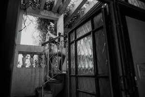 Elegant woman in 1920s costume posing on a staircase in Buenos Aires.